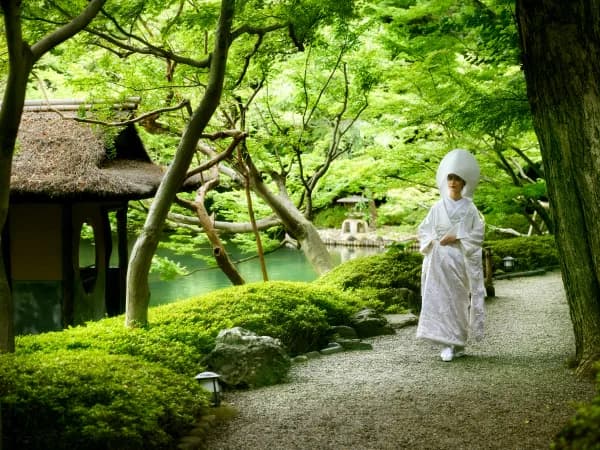 八芳園の日本庭園と池の景色の中、歩く白無垢の花嫁